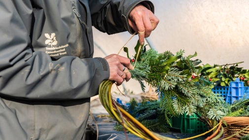 A person making a decorated willow wreath at Llanerchaeron, Ceredigion